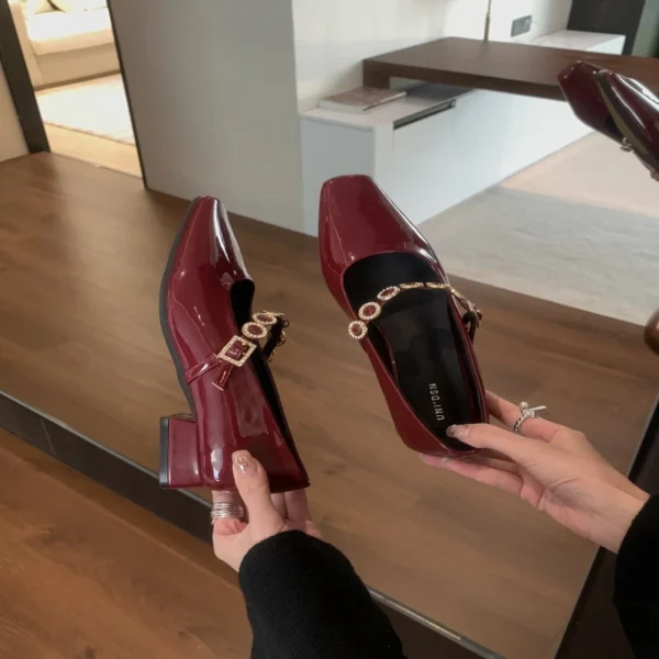 Burgundy patent leather square-toe heels with crystal-embellished straps.