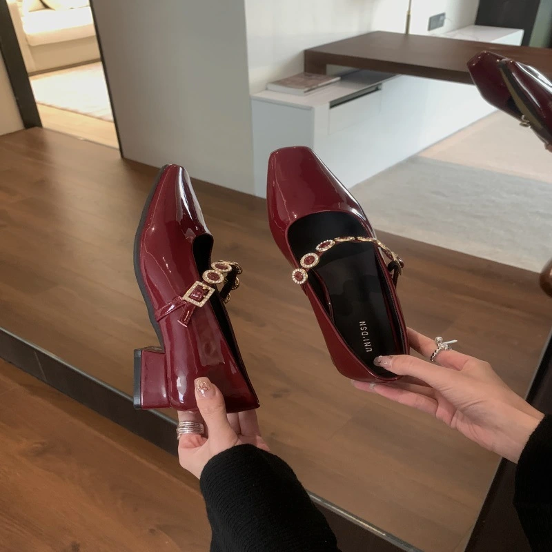 Burgundy patent leather square-toe heels with crystal-embellished straps.