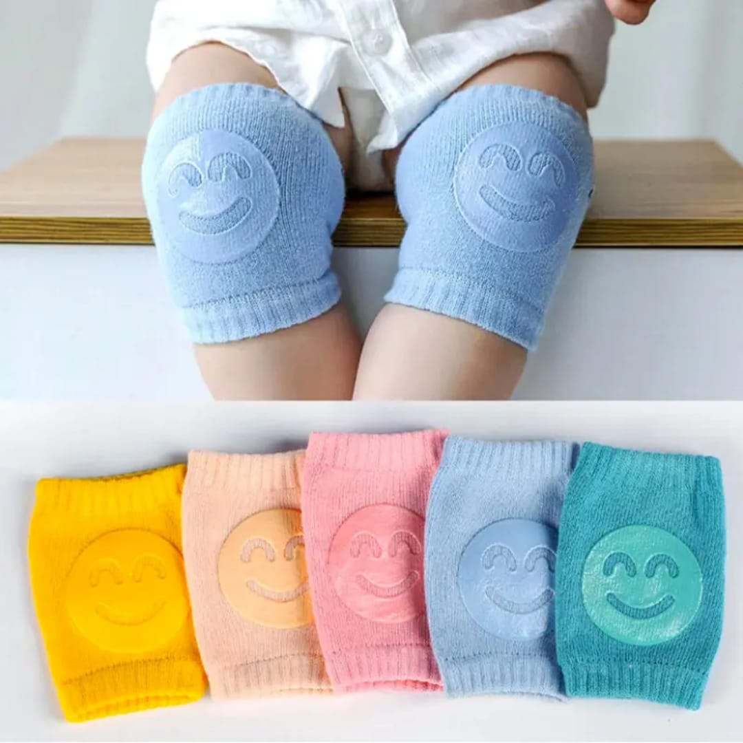 Colorful baby knee pads with anti-slip silicone smiley grip made from soft breathable cotton for crawling babies, available in yellow, cream, pink, blue and mint green.