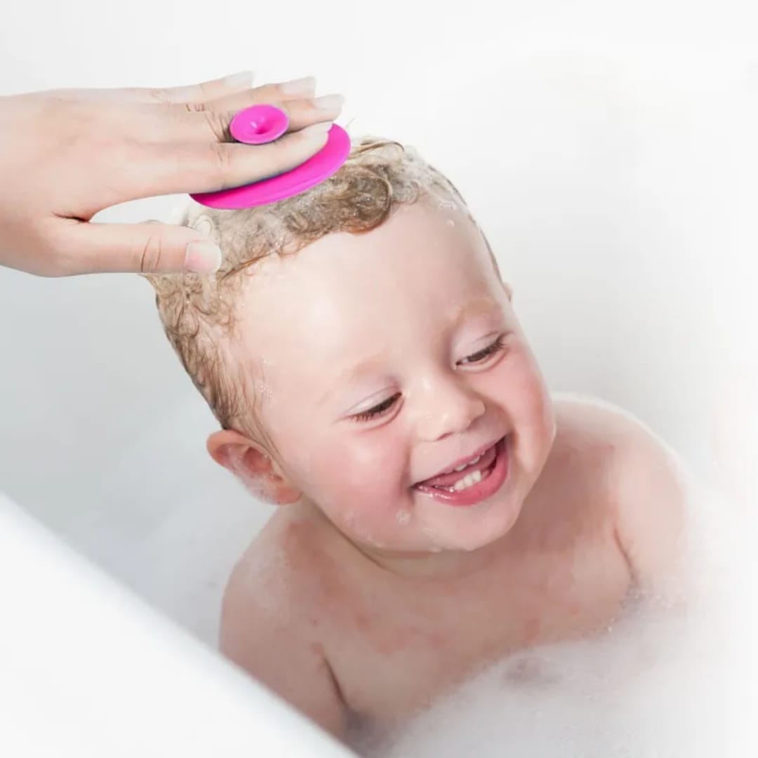 Soft pink silicone baby hair brush with finger grip for gentle scalp massage, cradle cap removal, and newborn hair care.